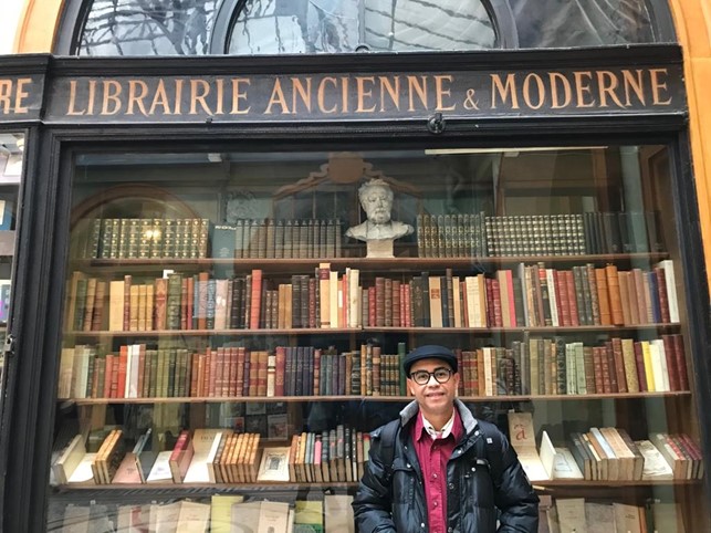 Foto de Edson Francisco de Andrade na frente da livraria Librairie Ancienne & Moderne, em Paris, França.