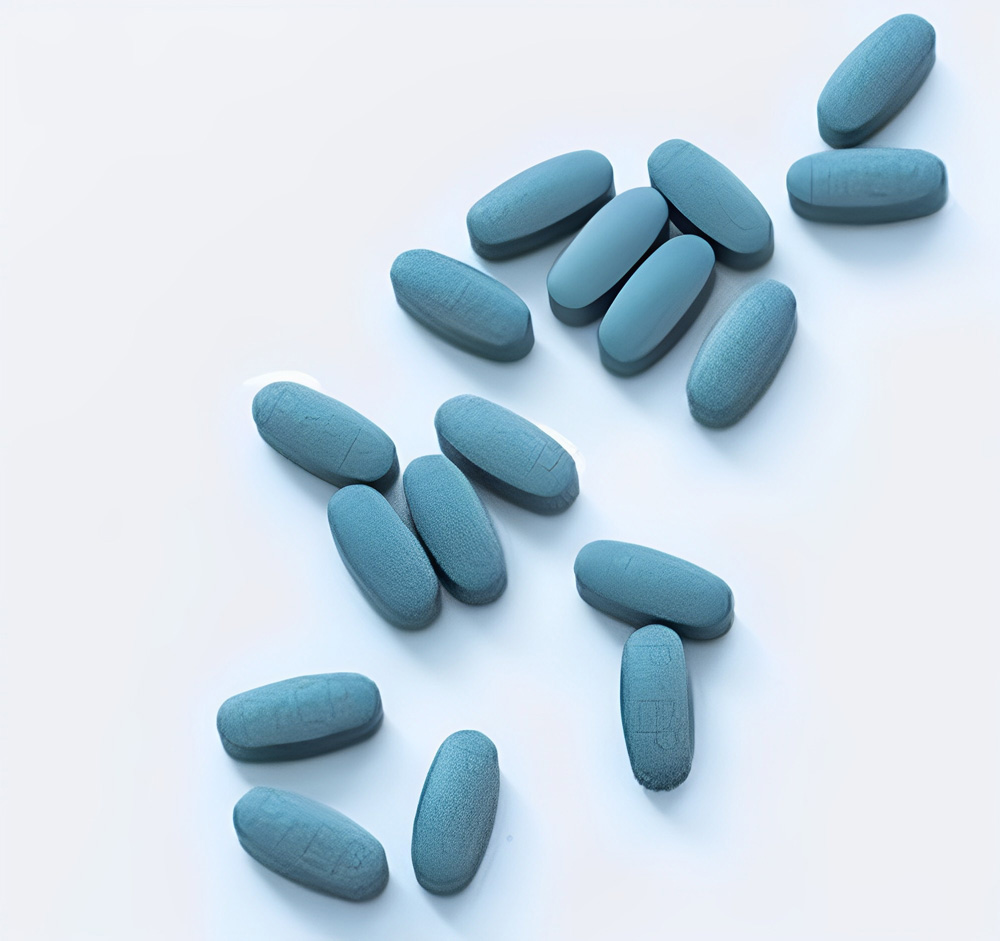 Pílulas azuis espalhadas sobre um fundo branco.