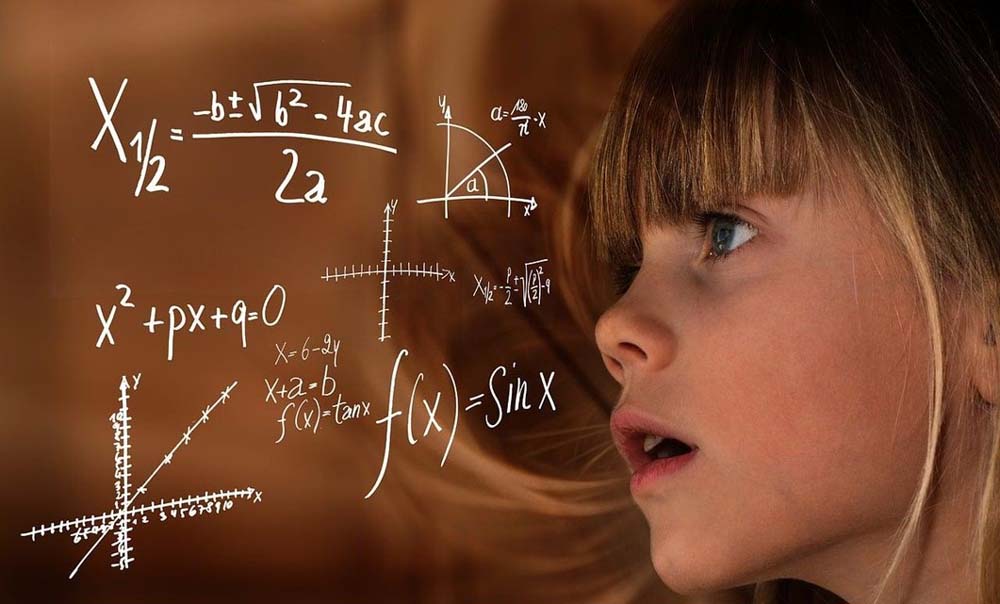 Garota de cabelos loiros ao vento e olhos verdes, vista de perfil, olhando na direção de equações matemáticas suspensas no ar.