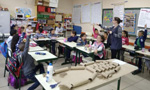 Professora e alunos desenvolvendo atividades na sala de aula.