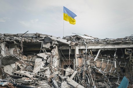 Bandeira da Ucrânia posta sobre destroços de guerra.
