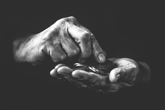 Imagem em preto e branco mostra mãos segurando algumas moedas. Uma das mãos está aberta, com moedas empilhadas sobre a palma, enquanto a outra mão usa um dedo para contar ou manusear o dinheiro. O fundo escuro destaca o contraste das mãos e das moedas Imagem em preto e branco mostra mãos segurando algumas moedas. Uma das mãos está aberta, com moedas empilhadas sobre a palma, enquanto a outra mão usa um dedo para contar ou manusear o dinheiro. O fundo escuro destaca o contraste das mãos e das moedas