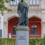 fotografia do monumento a Schelling na Maximiliansstraße, em frente ao prédio do governo. Erigido em 1861 "por seu grato aluno Maximiliano II, Rei da Baviera" ao filósofo falecido em 1854.