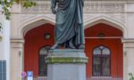 fotografia do monumento a Schelling na Maximiliansstraße, em frente ao prédio do governo. Erigido em 1861 "por seu grato aluno Maximiliano II, Rei da Baviera" ao filósofo falecido em 1854.